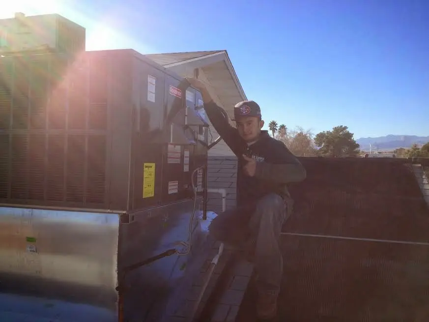 HVAC technician performing Air Duct Repair on a rooftop unit in San Diego Country Estates